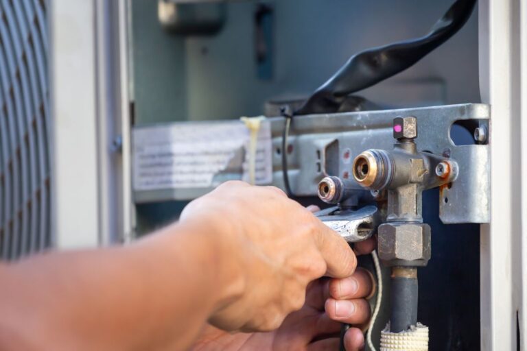 Close-up of Technician man using a wrench fixing modern air conditioning system