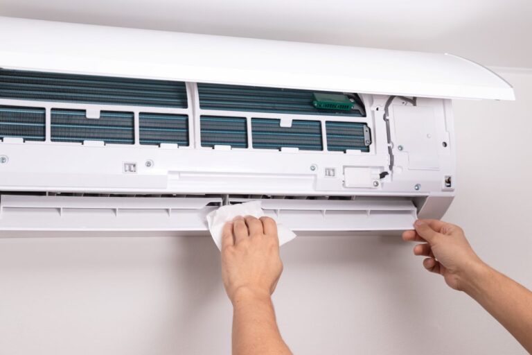 Close up of man cleaning air conditioner unit with a soft cloth