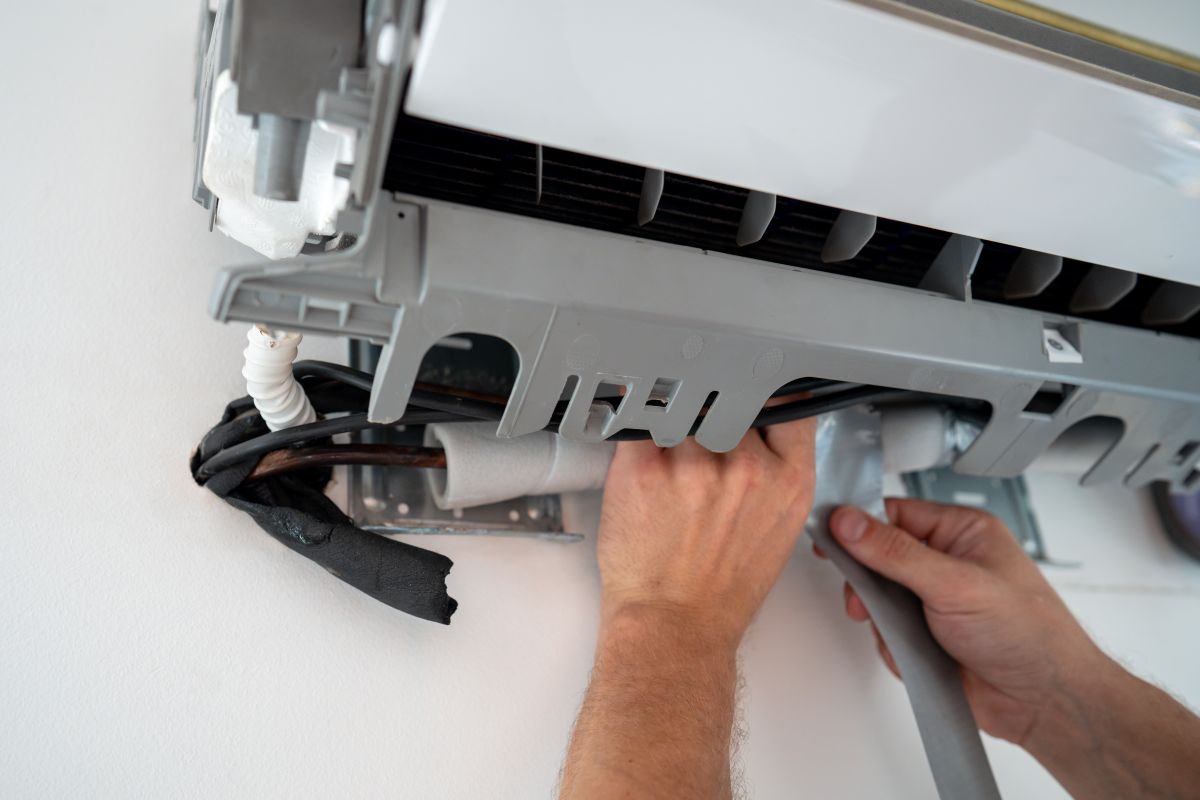 hvac troubleshooting hands repairing wall unit indoors