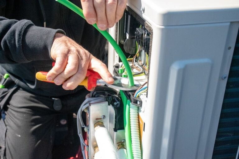 Close-up of Handyman Fixing Electrical Wiring in Outdoor Device