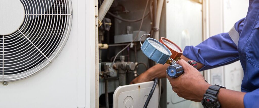 Heat and Air Conditioning, HVAC system service technician using measuring manifold gauge checking refrigerant