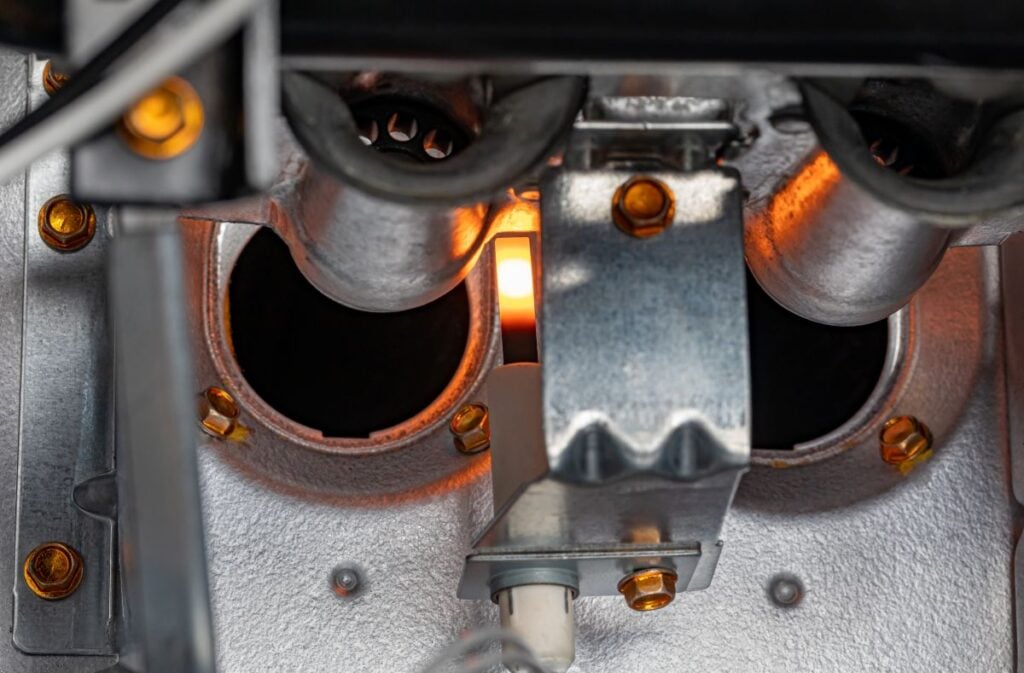 Gas furnace flame ignitor glowing and ready to ignite gas. HVAC maintenance, repair, service and installation