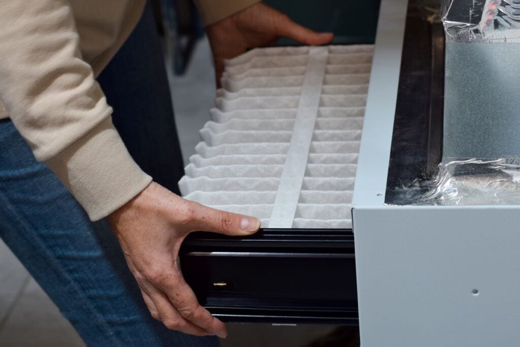 woman replacing furnace filter